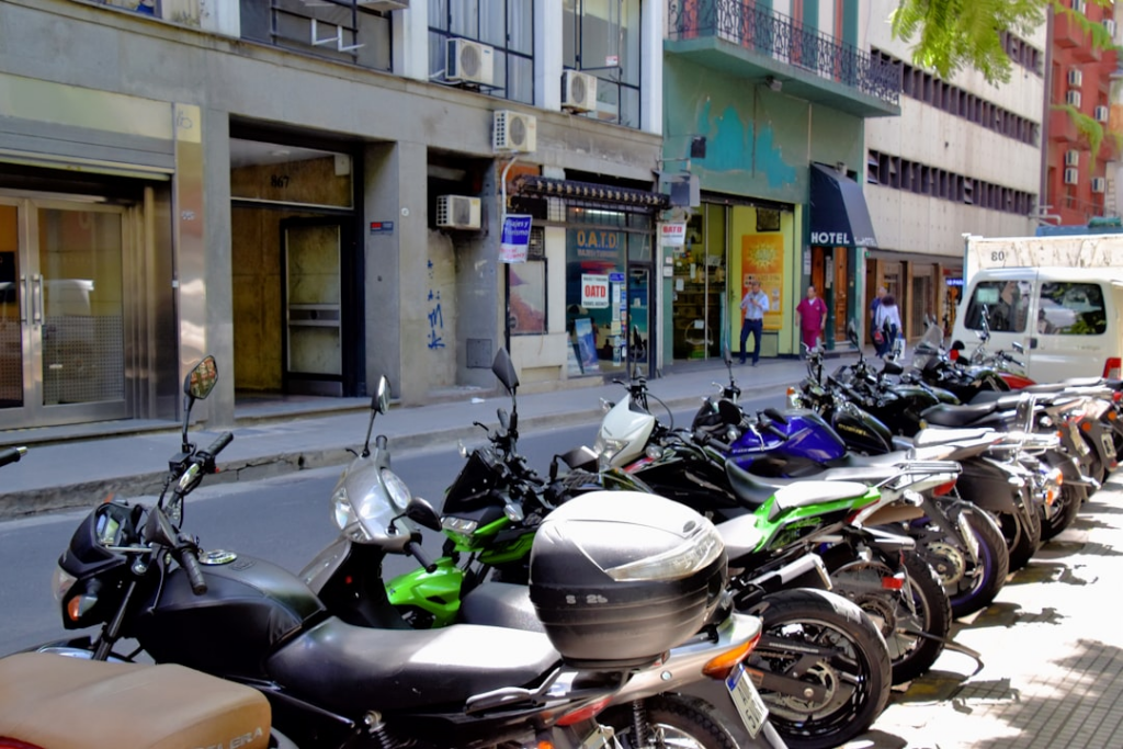 a row of motorcycles parked on the side of a street — Foto por Jeffrey Eisen na Unsplash